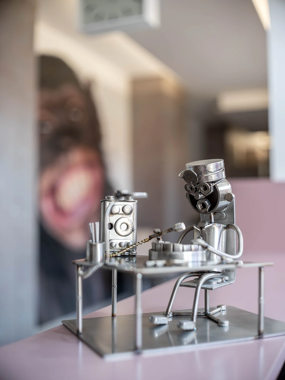 Detailaufnahme einer kleinen Metallfigur in einer modernen Zahnarzt- oder Dentallaborumgebung.